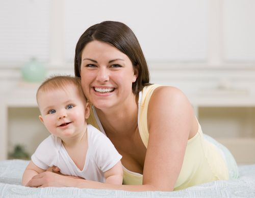 mother and baby lying down and smiling