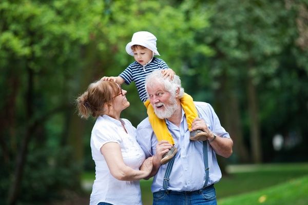 Grandfather parents and grandchild enjoying outdoor activity