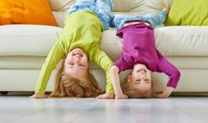 kids hanging upside down off of the couch