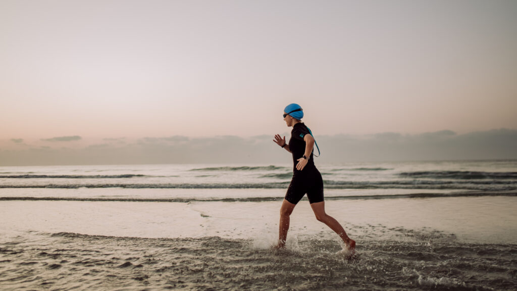 woman in neoprene running along of the ocean 2023 03 08 22 37 34 utc